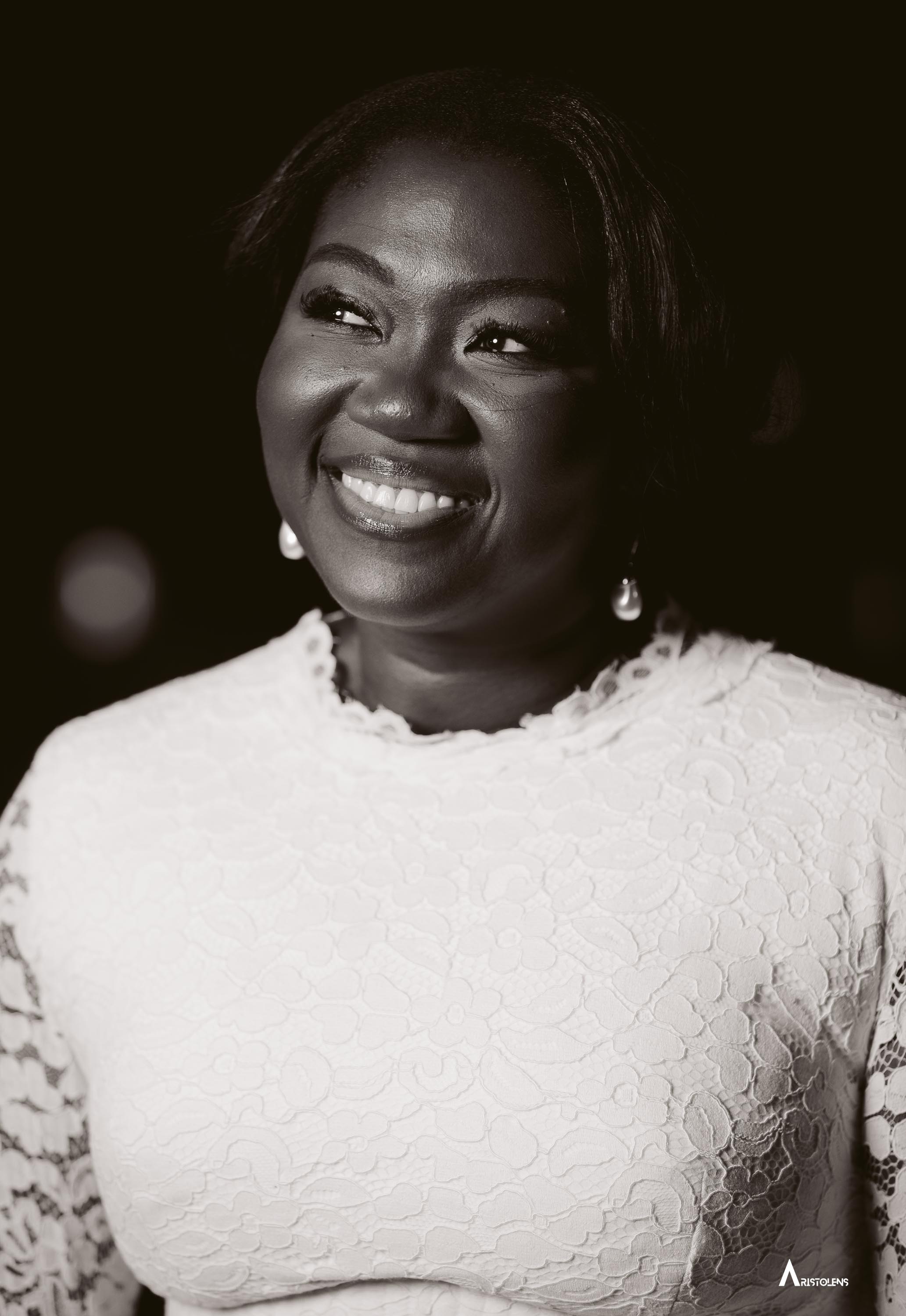 Editorial black and white portrait — a woman mid-laugh, captured by AristoLens.